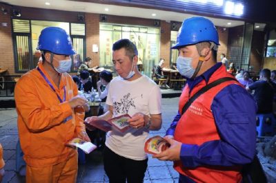 為各個(gè)攤位檢查用電安全情況、排查隱患、發(fā)放用電安全宣傳單